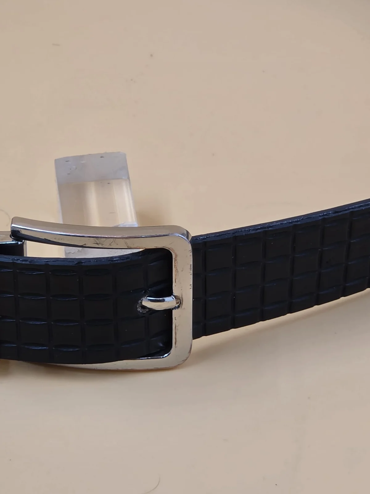 A closer view of the buckle and textured strap on the belt shown by SPY WORLD.