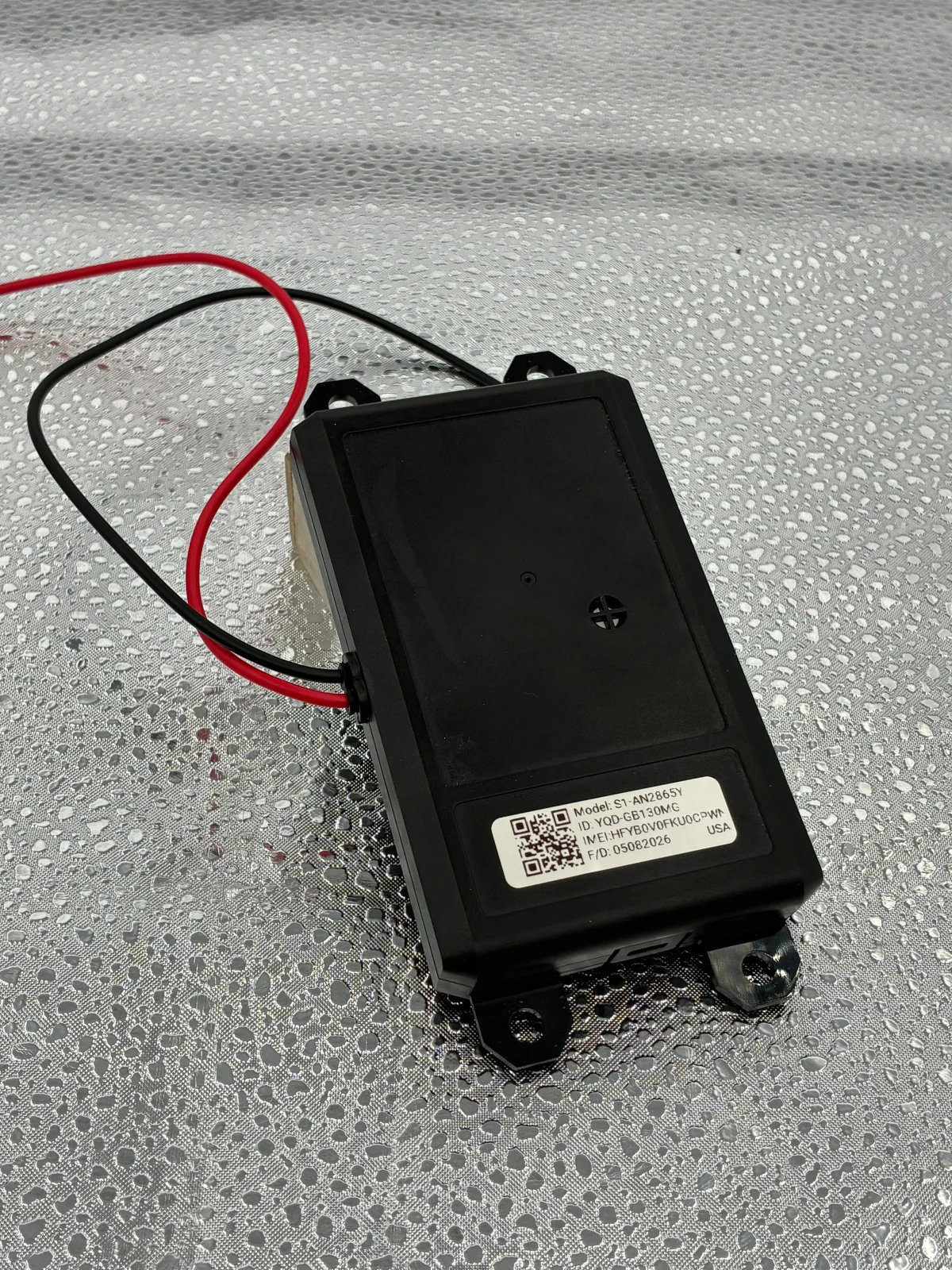 Close-up of the wired unit, showing its mounting tabs and connection leads.