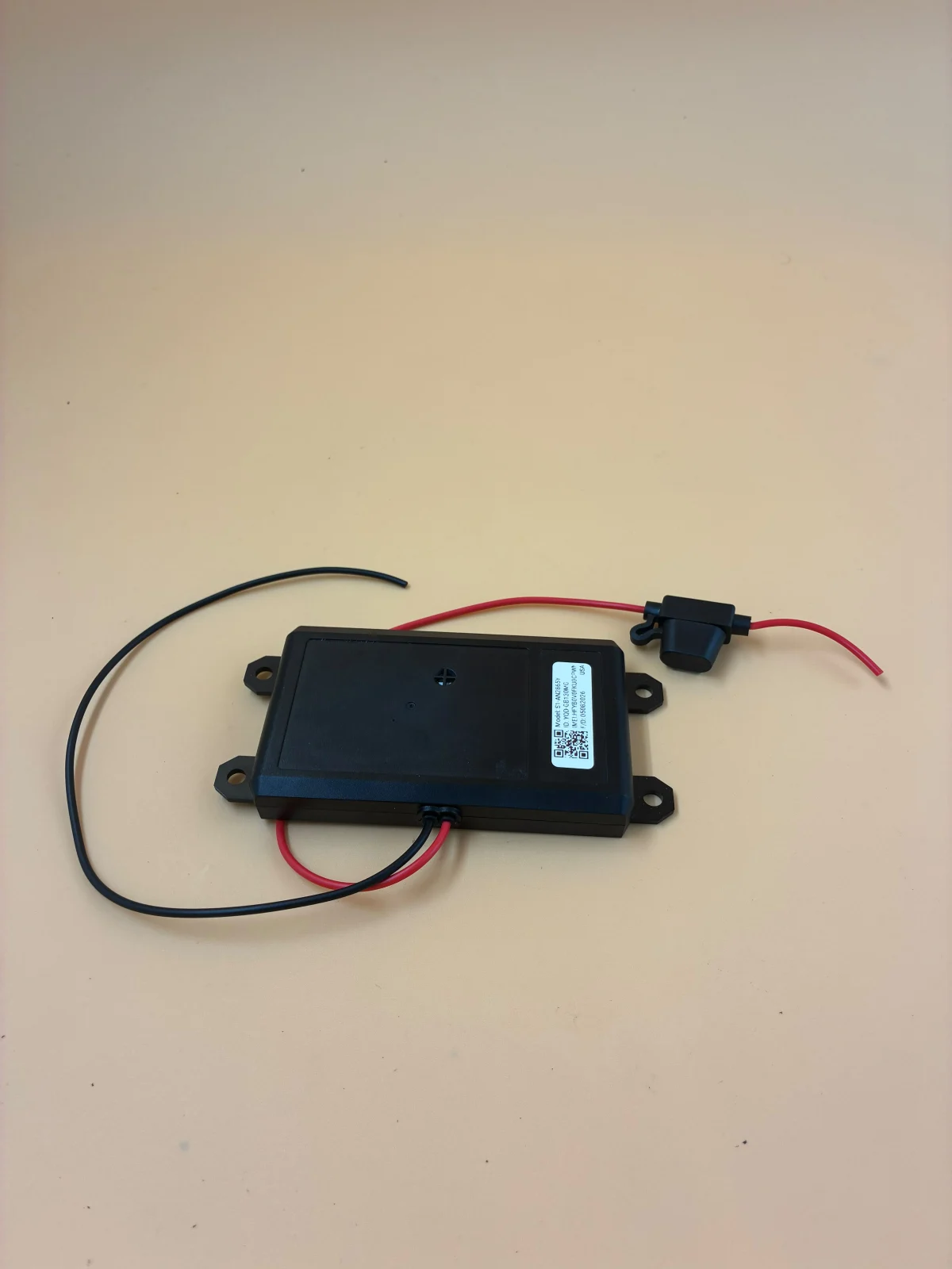 A commercial tracking unit shown with its wiring and mounting points.