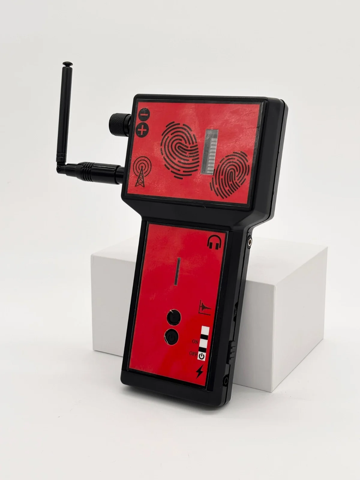Vista frontal de un detector rojo y negro con antena lateral