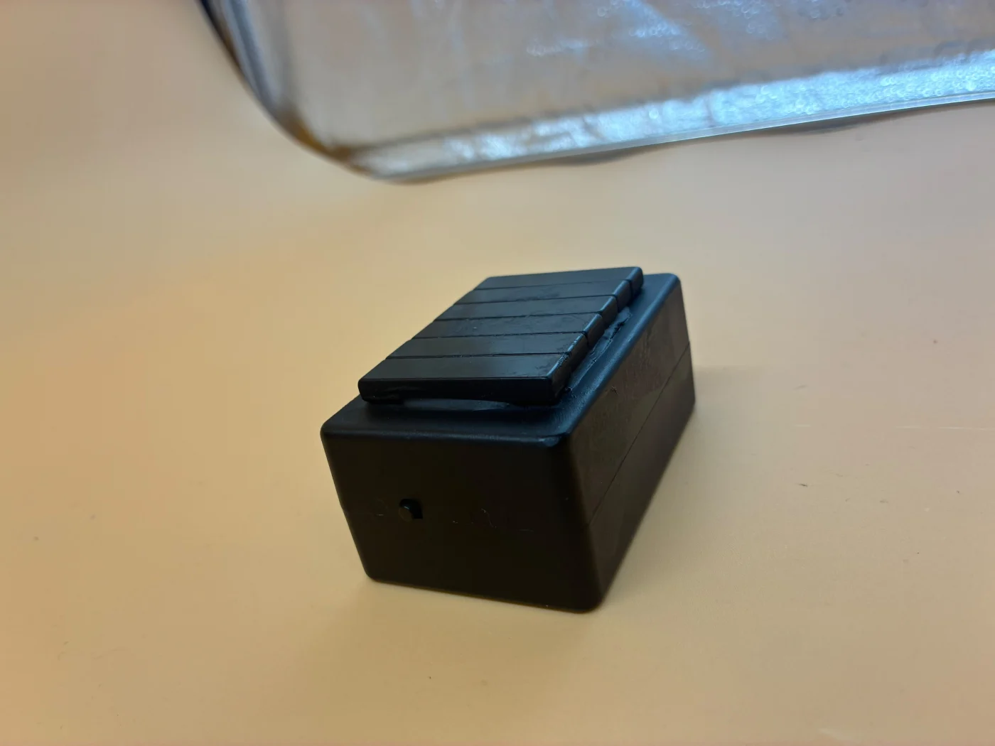 Side view of a black case with a raised section on top.