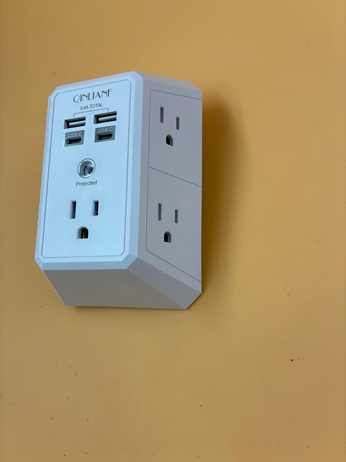 White outlet-adapter-style housing shown at an angle, with front and side outlets and USB ports visible.