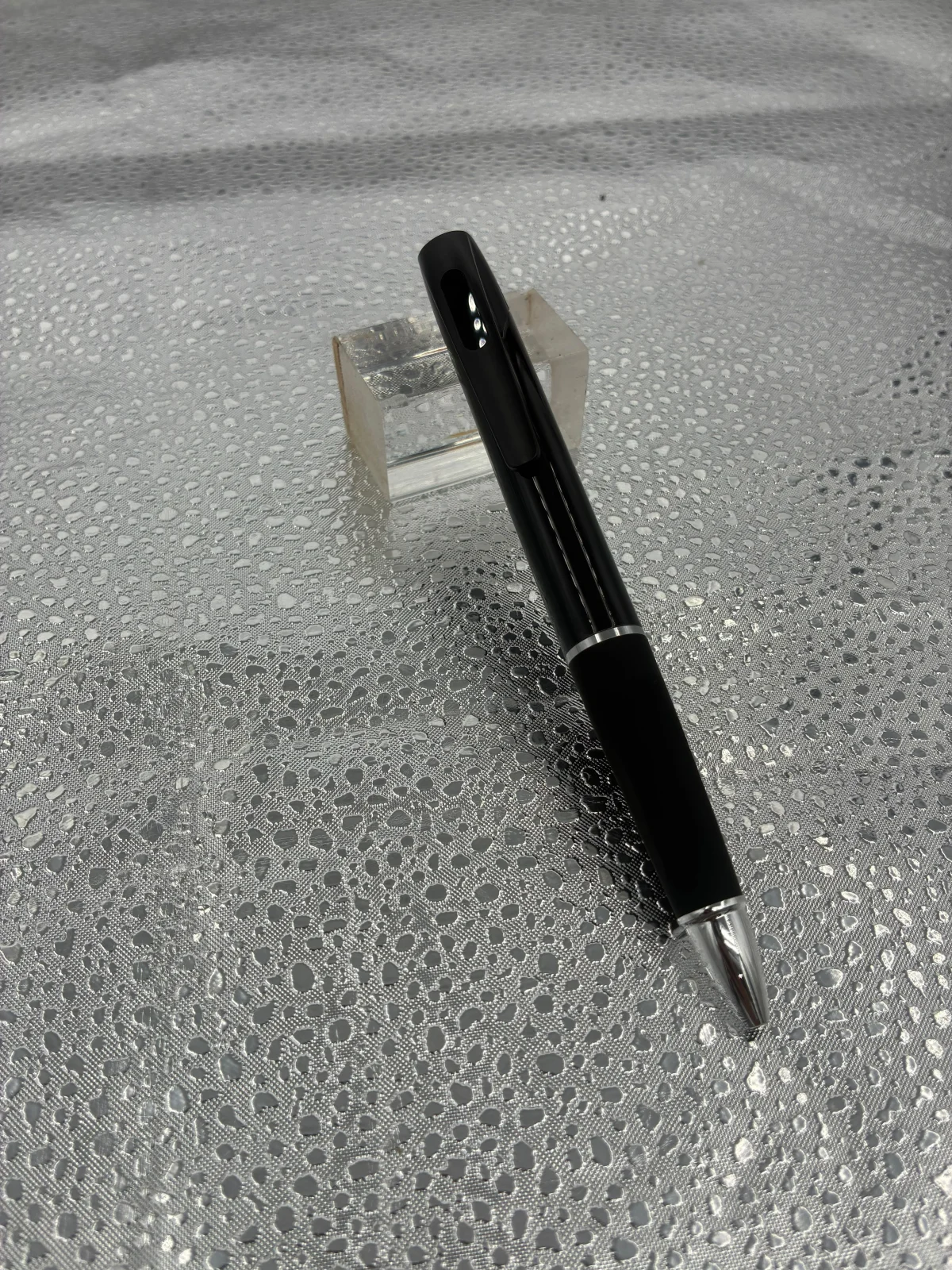 Angled view of the black pen, showing the pocket clip and silver-colored accents.