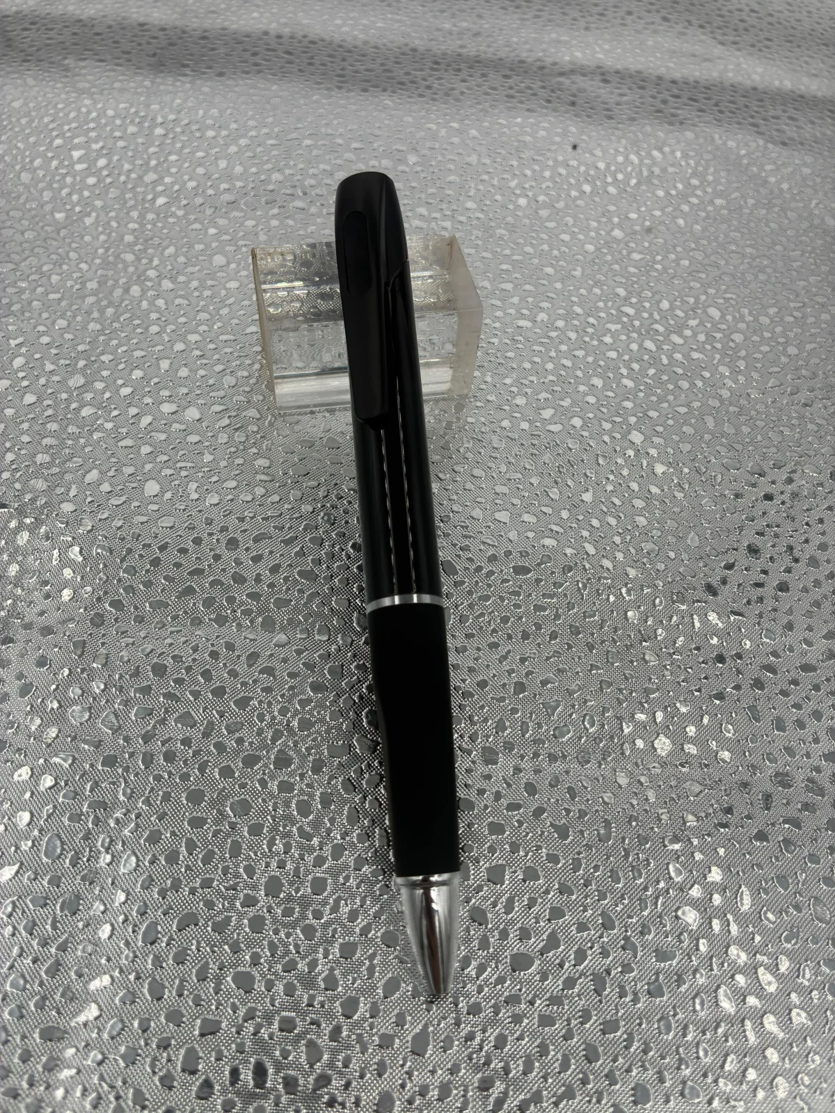 Front view of the pen resting against a clear display support.